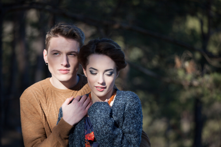 beautiful couple embrace on a walk in the woods