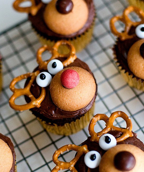 Rudolph the red nosed reindeer inspired Christmas cupcake. The chocolate cupcakes are designed on top to look like Rudolph and his shiny red nose with knotted pretzels as the antlers and icing as the googly eyes.