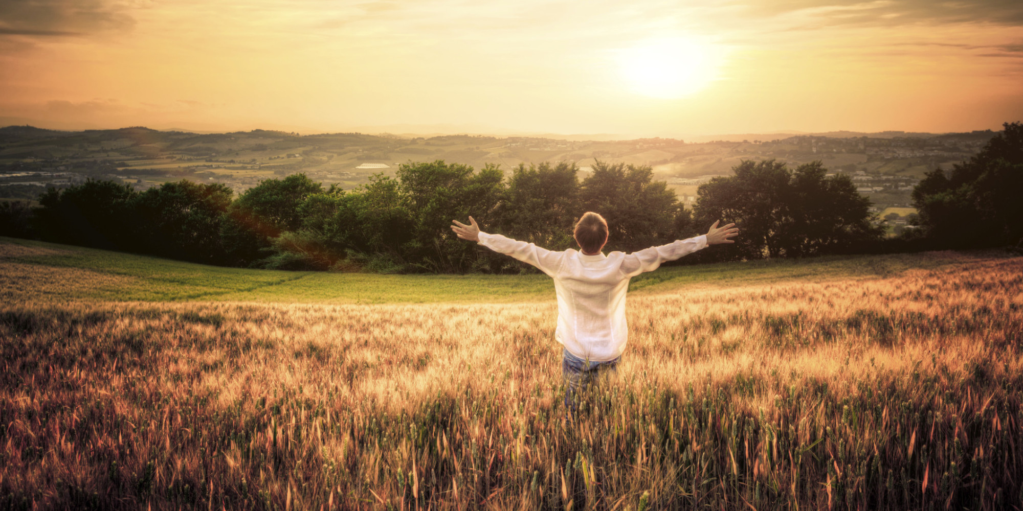 Free Man with Open Arms in Wheat Field at Sunset